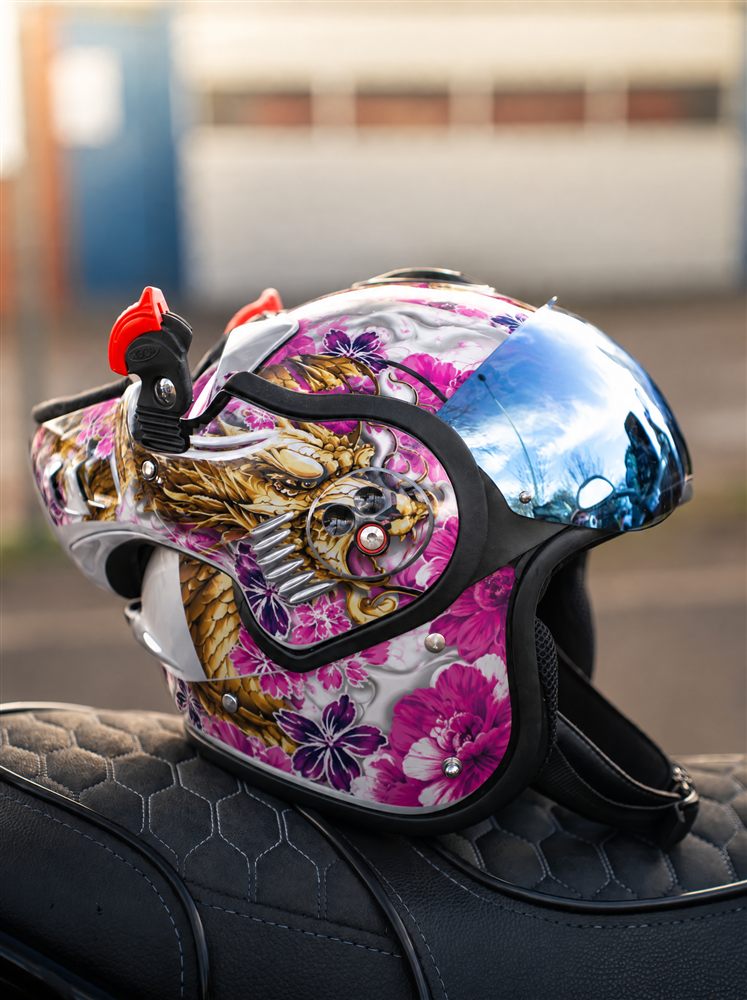 Helmet with a pink dragon kit on a seat